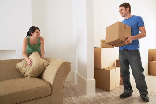 Mover wearing PPE while lifting furniture during a house relocation